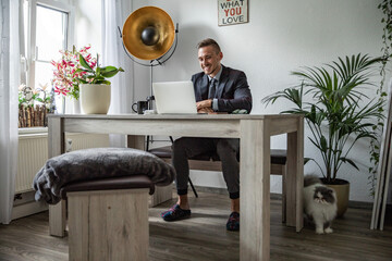 Junger Mann im Homeoffice Arbeiten am Schreibtisch Laptop konzentriert produktiv im modernen...