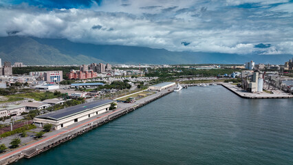 Fototapeta premium Scenic view of Hualien harbor in Taiwan with mountains and modern buildings under a blue sky