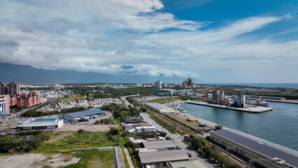 Aerial view of Hualien port area with lush greenery and urban landscape under a bright blue sky