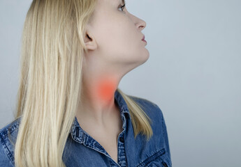 Thyroid disease. Woman points to her neck where the thyroid gland is located. Examination and...