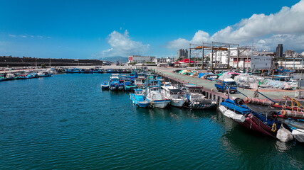 Fishing boats docked at the busy harbor in Hualien, Taiwan under a clear blue sky in daytime