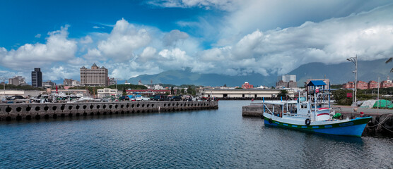 Fishing boat docked near Hualien harbor with a backdrop of clouds and mountains in Taiwan