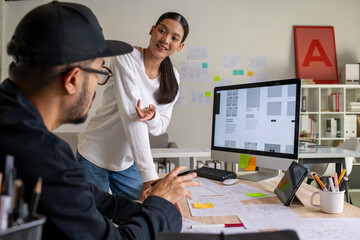 UX UI designers discussing and brainstorming on wireframes for a website and mobile app prototype, in the concept of website and mobile application design concept.