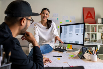 UX UI designers discussing and brainstorming on wireframes for a website and mobile app prototype,...