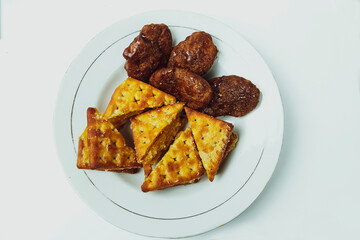 Taripang biscuits and cakes are placed on a white plate on a plain white table