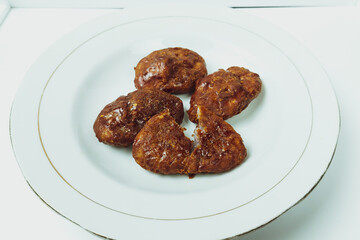 Taripang cake on a white plate on a plain white table in the dining room