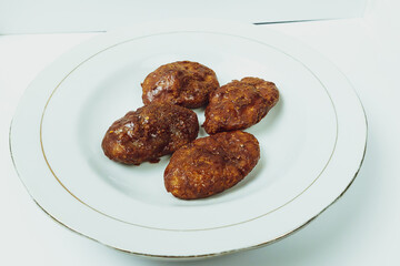 Taripang cake on a white plate on a plain white table in the dining room