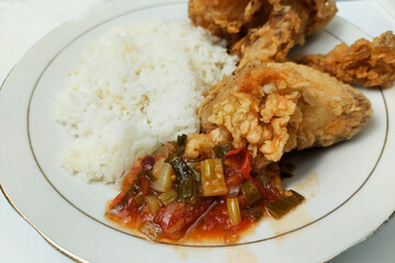 Rice mixed with flour fried chicken on a white plate on the table