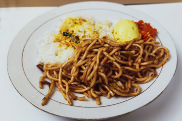 Rice mixed with fried omelet on a white plate on the table