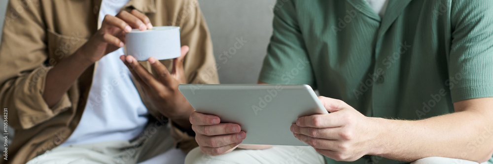 Poster two people collaborating, one holding tablet while another gestures with coffee cup. sharing informa