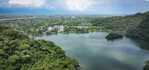 Naklejka premium Aerial view of lush green landscape with serene lake in Taiwan during daylight