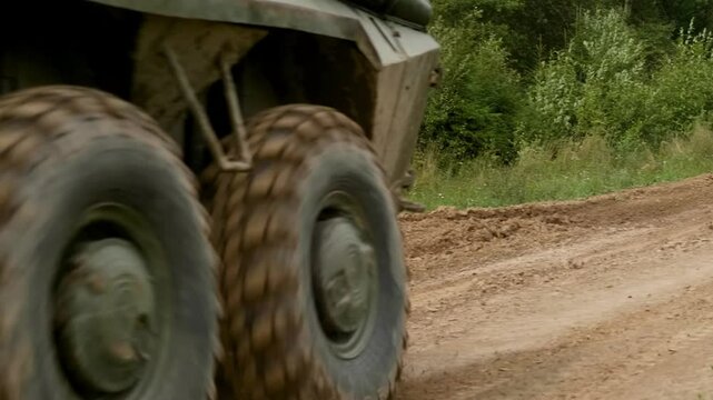The armored personnel carrier moves across a military proving ground, demonstrating its amphibious capabilities and robust design, intended for transporting personnel and providing fire support.