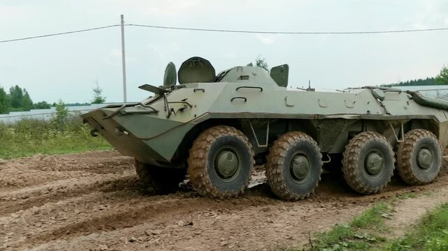 A BTR-70 drives through a military training ground, showcasing its amphibious capabilities and robust design for transporting personnel and providing fire support.