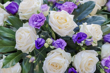 Flower arrangement. A beautiful blue and white memorial bouquet at the cemetery. Memorial flowers include white roses and blue eustoma.