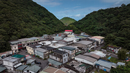 Fototapeta premium Charming mountain village in Nanfangao, Taiwan, with lush greenery and traditional style