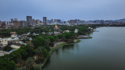 Urban landscape at dusk in Kaohsiung Taiwan showcasing river, buildings, and lush greenery