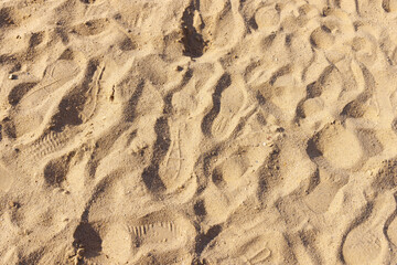 Shoe prints on the surface of dry sand. View from above.
