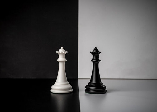 Conceptual composition with chess pieces in dramatic light, duality, good versus evil, darkness versus light, conflict.