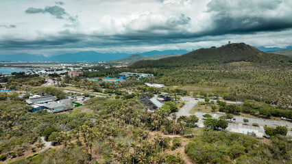 Fototapeta premium Aerial view of green landscape with palm trees and mountains in Taiwan under a cloudy sky