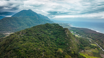 Fototapeta premium Scenic view of lush green mountains and coastline in Taiwan during an overcast day