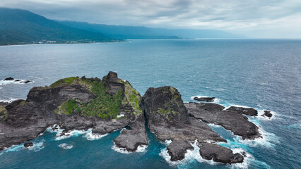 Natural rock formations along the coastline of Taiwan under a cloudy sky during the day