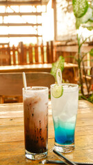 Blue squash drink and chocolate shake on wooden table with aesthetic wooden cafe background