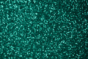 Shining green bokeh background. Blurred sequins festive texture. Christmas background.