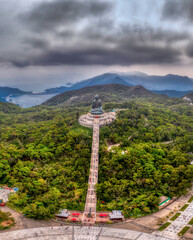 Amazing aerial view of Tian Tan Buddha-Big Buddha Hong Kong by drone with a lush forest and the...