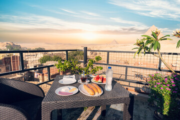 Traveler's breakfast. table in an outdoor restaurant with a fantastically beautiful view of the great pyramids of Giza. Cairo. Egypt. Romantic dinner on the roof with a beautiful view.