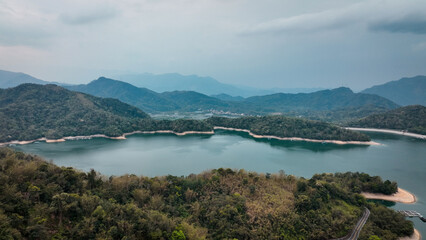 Fototapeta premium Discover the tranquil beauty of Sun Moon Lake, framed by lush mountains and serene waters