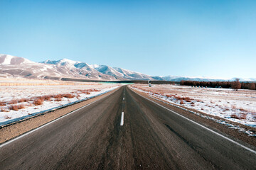 Uphill road landscape in winter Iceland. Asphalt road with sideways full of snow