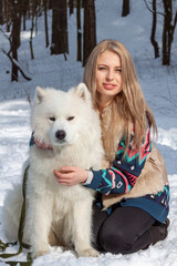 A beautiful young blonde with a white husky dog