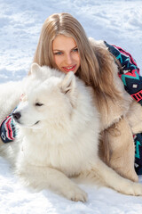 A beautiful young blonde with a white husky dog