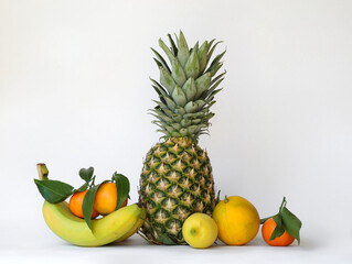 Fruits on a white background. Pineapple, bananas and citrus fruits.