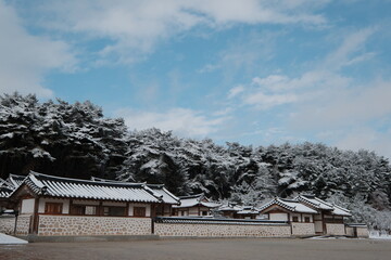 대한민국 전통의 건축물 한옥과 눈 쌓인 소나무에 상고대 함박눈이 어우러진 푸른 하늘의 하얀 겨울의 설경