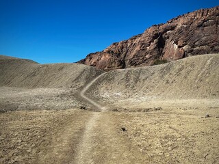 A trail winds through isolated desert and over a hill (Terlingua, Texas, USA)