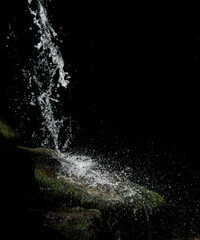 Waterfall. Close-up of the cold water flow of a waterfall with contrasting shadows on a sunny day.