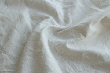 Grey textile napkin in white color as background. Folded decorative kitchen cotton towel