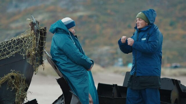 Young fisherman communicates with elderly woman and vividly tells a story about his resent fishing