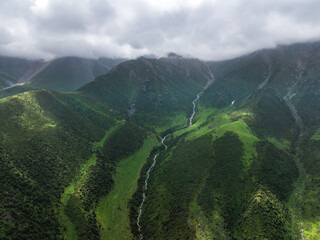 A mountain river, a stream meanders among the green slopes of the mountain. Summer landscape,...