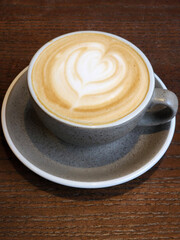 Gray cup of coffee on a brown table. Cup of brewed coffee