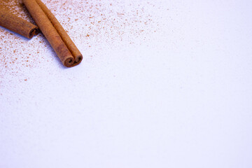 A pile of orange slices and cinnamon sticks on a white background. The oranges are cut in half and the cinnamon sticks are whole. Concept of warmth and comfort