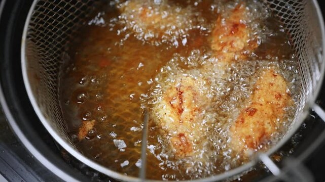 Du poulet en train de frire dans une friteuse