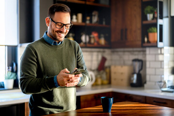 Man using smartphone and laptop computer for electronic banking, making reservation, online shopping