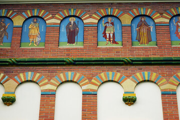 Obraz premium Icons on the facade of the Church of the Holy Trinity, part of the Orthodox monastery of Sinaia in Romania - a fragment of the wall decoration close-up. Famous sights of the Carpathians.