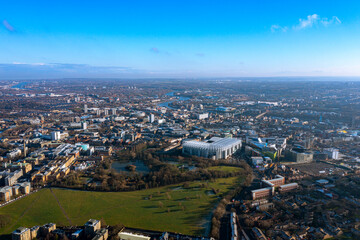 Panoramic aerial view of Newcastle city, showcasing iconic landmarks, green spaces, and the River Tyne under a clear blue sky. Perfect for urban landscape and travel content