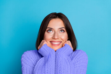 Portrait of attractive cheerful curious girl looking up copy space isolated over shine blue color...