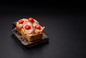 Sandwich with brioche, meat, melted cheese, ham, tomatoes, salt, spices and herbs
