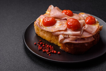 Sandwich with brioche, meat, melted cheese, ham, tomatoes, salt, spices and herbs