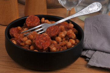 Ramequin de pois chiches et rondelles de chorizo avec une fourchette en gros plan